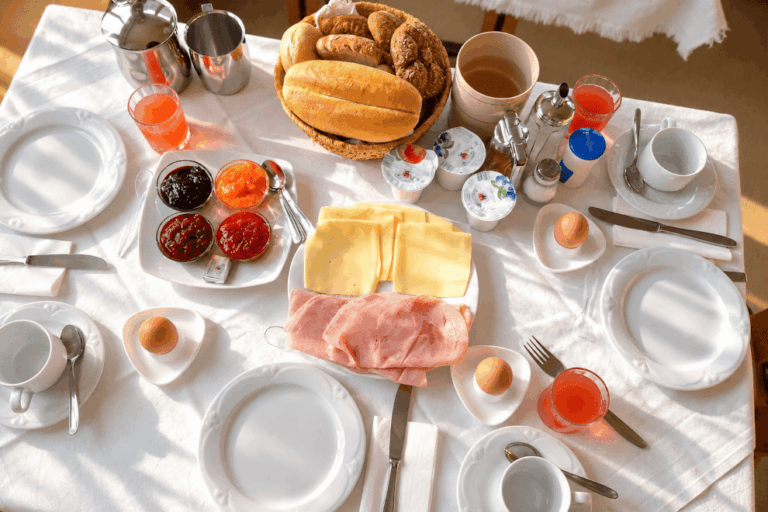 Tavola apparecchiata per la colazione con panini, marmellate, formaggio, prosciutto e uova delle nostre galline in Val d’Ultimo